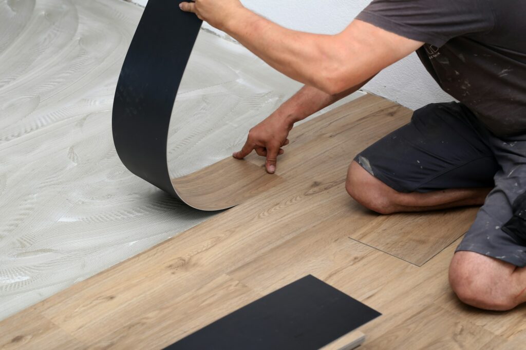 Worker installing new vinyl tile floor